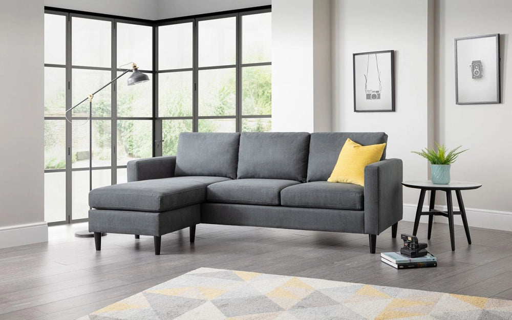 Aria Upholstered Corner Sofain Grey Finish with Four Wooden Leg Coffee Table and Standing Lamp in Livng Room Setting