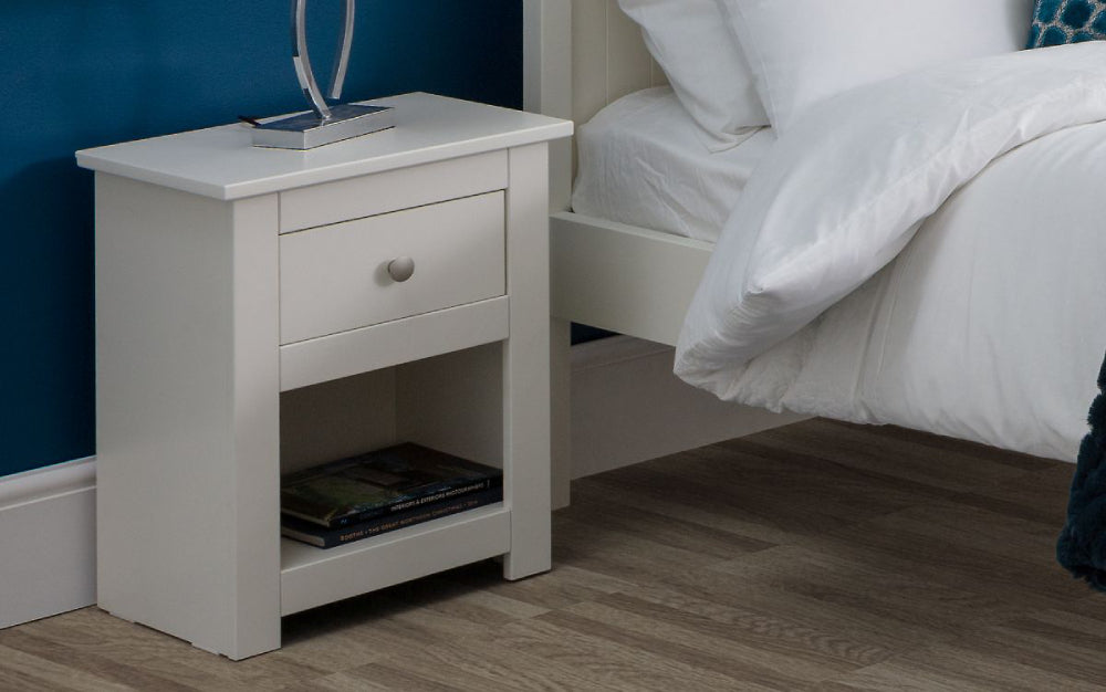Bradley Bedside Table in White Finish with Books and Pillows in Bedroom Setting