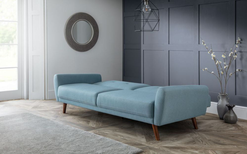Capri Sofa Bed Blue with Flower Vase and Ceiling Light in Living Room Setting