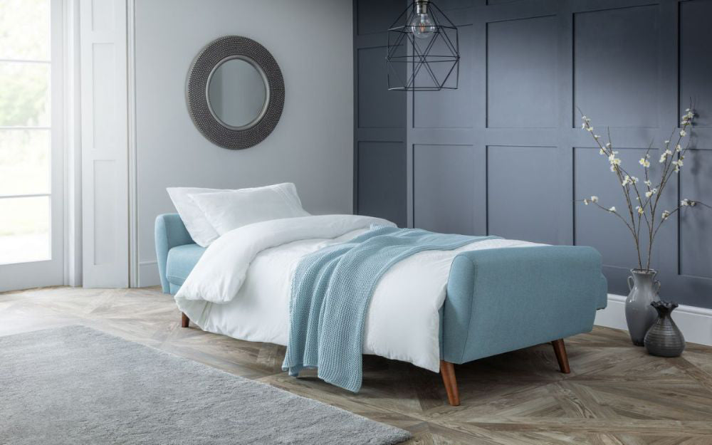 Capri Sofa Bed Blue with White Duvet and Throw in Living Room Setting