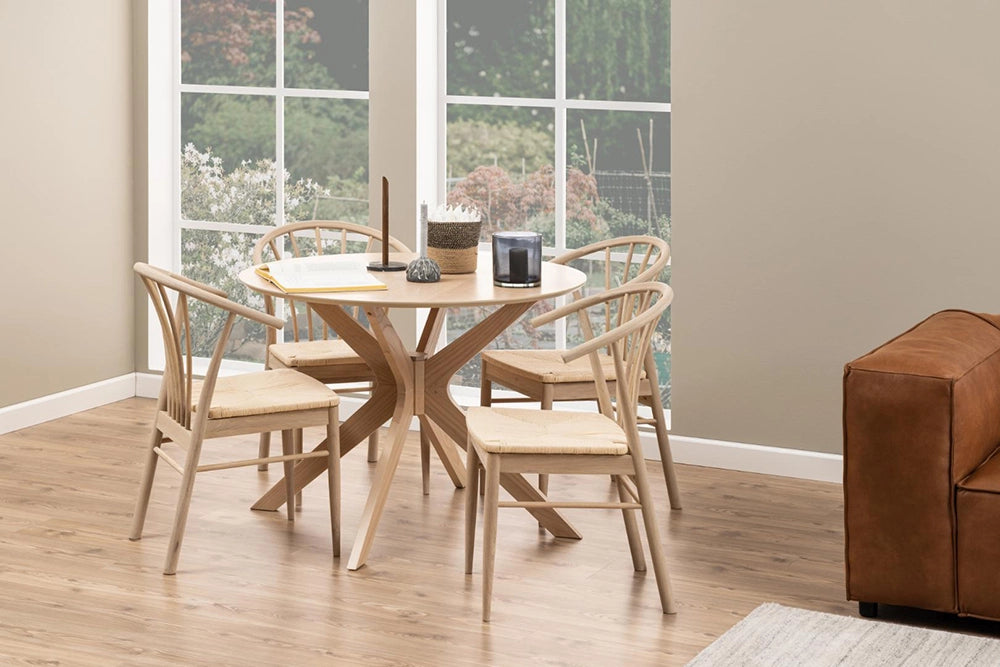 Danica Round Dining Table in White Oak Finish with Wooden Chair and Upholstered Sofa in Breakout Setting