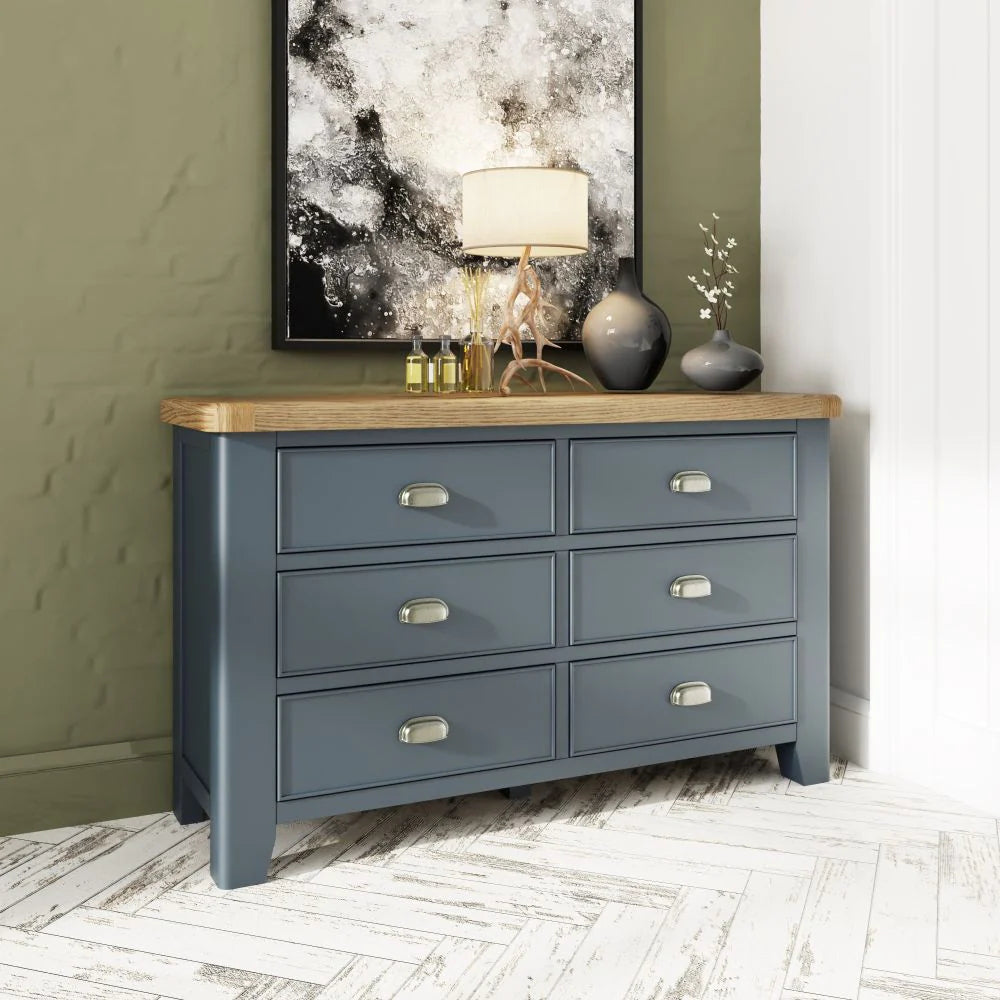 Hadley 6 Drawer Chest in Blue Finish with Lampshade and Flower Vase in Bedroom Setting