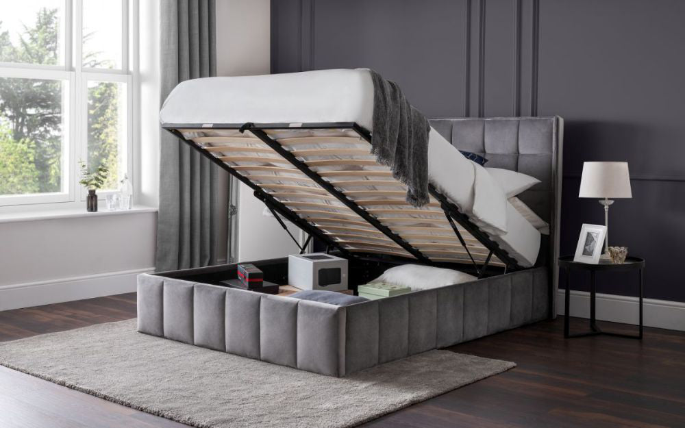 Jay Super King Sized Ottoman Bed in Light Grey Finish with Lampshade and Carpet in Bedroom Setting