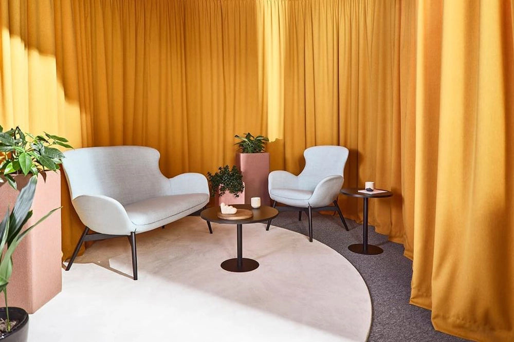 Kate Moodlii Upholstered Sofa in White Finish with Round Coffee Table and Pink Pot in Breakout Setting