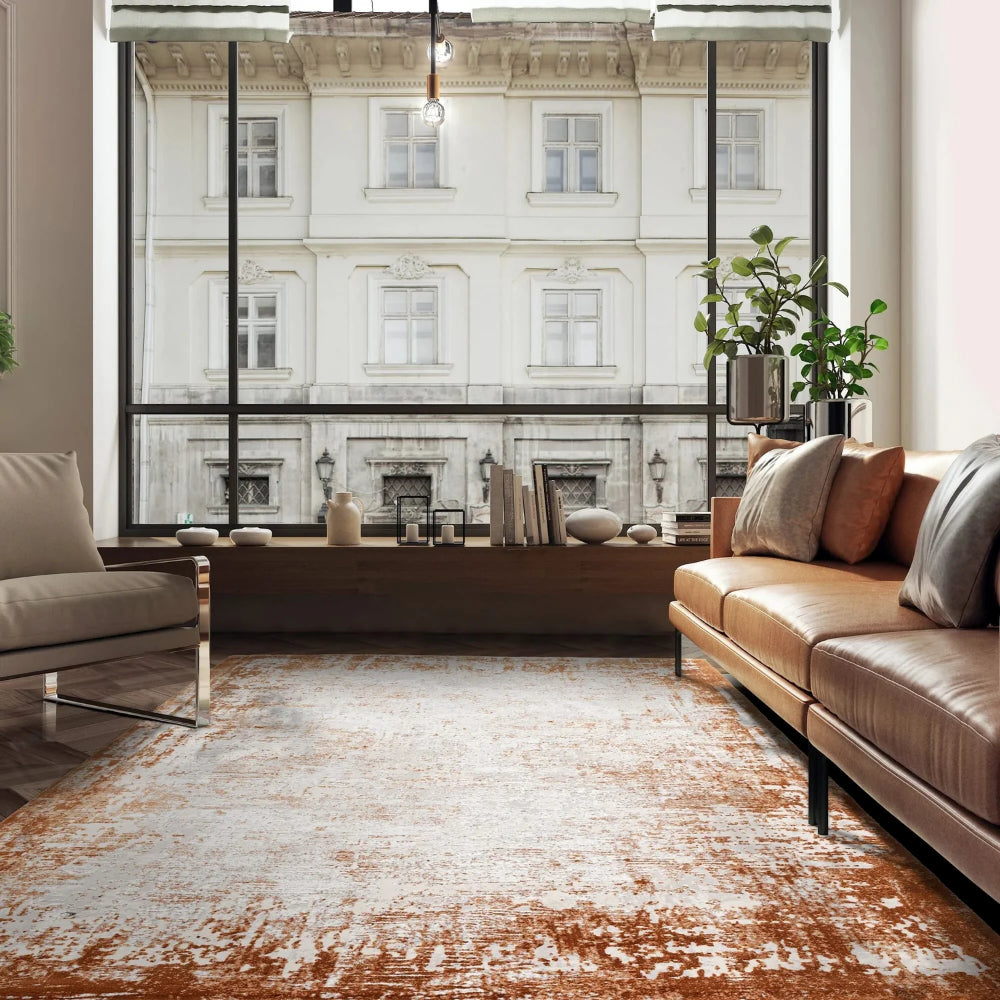 Kazzie Border Rug in Terracotta Finish with Sofa and Indoor Plant in Living Room Setting