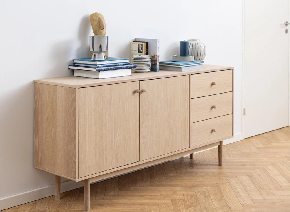 Krutcher Sideboard in White Oak Finish with Saucer and Books in Living Room Setting
