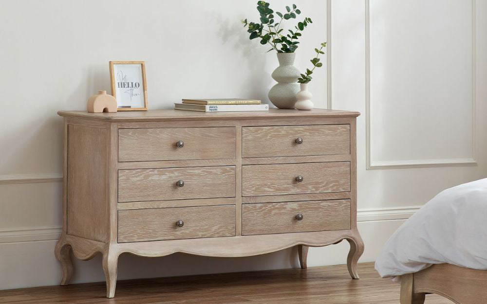Marseille 6-Drawer Wide Chest with Bed and Books in Bedroom Setting