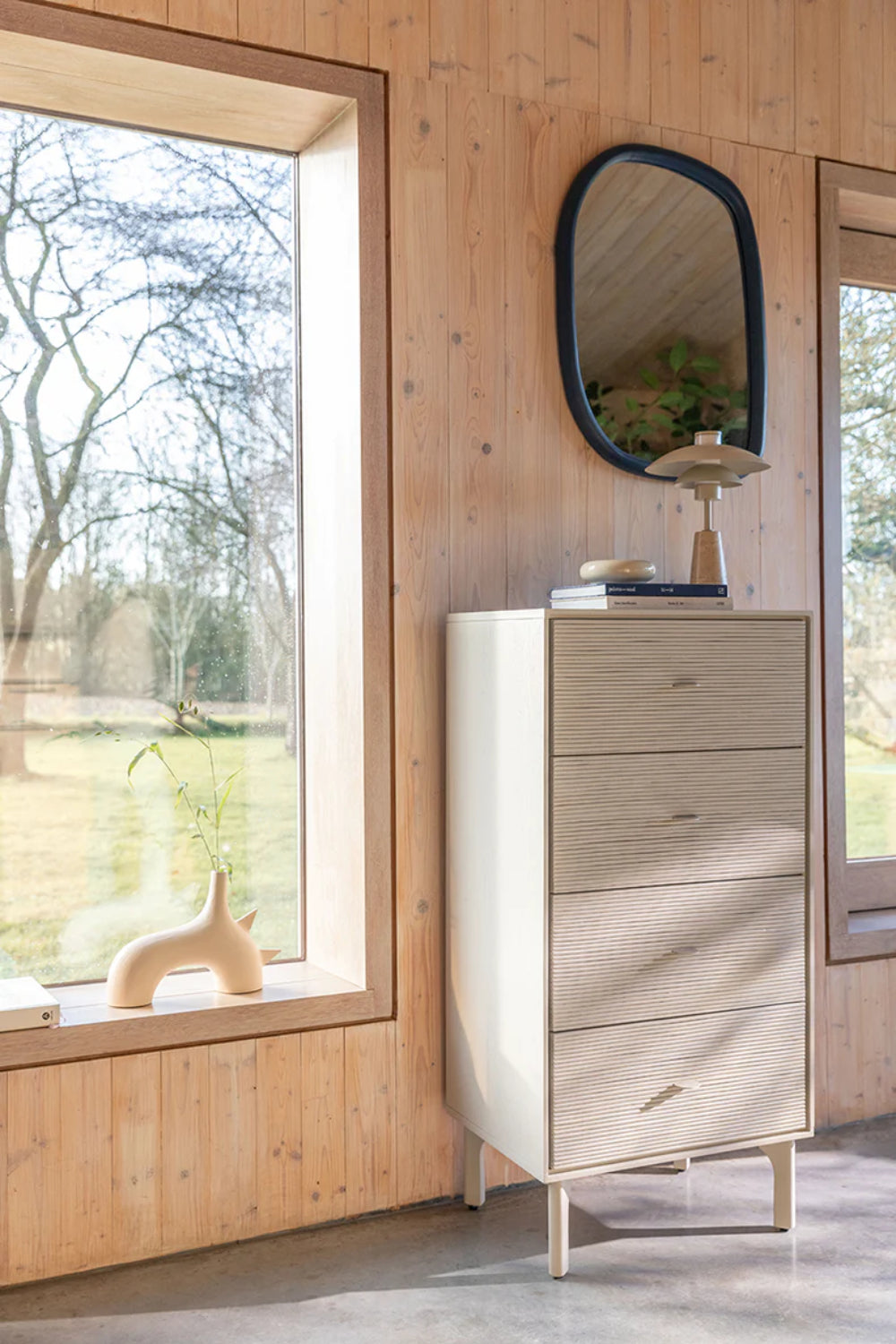Mosaic Chest Drawers with Books on Top and Wall Mirror in Breakout Setting