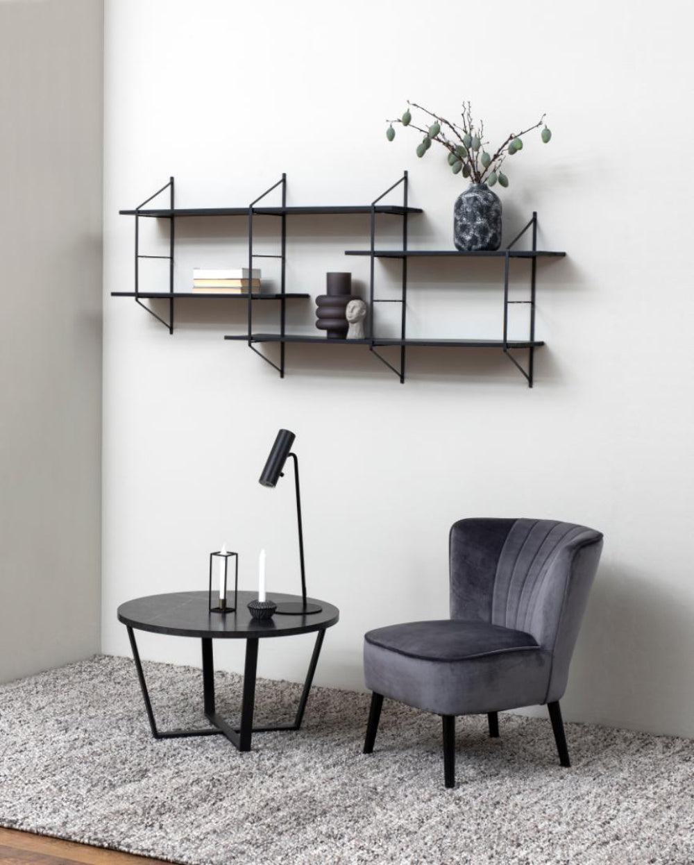 Ramble Round Coffee Table in Black Marble Finish with Lamp and Chair in Living Room Setting