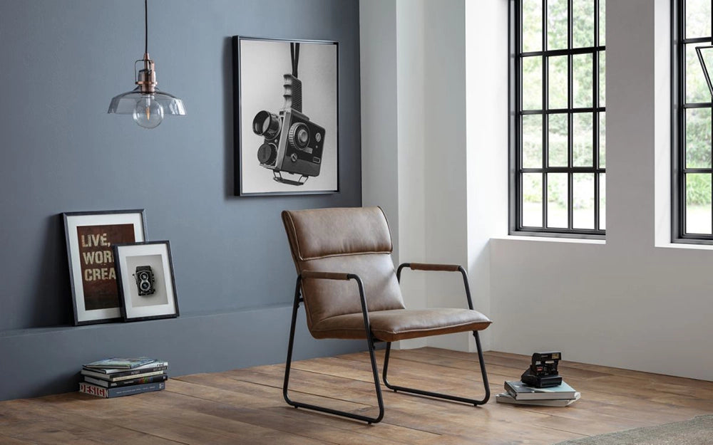 Travis Accent Chair in Brown Finish with Wall Frame and Ceiling Light in Studio Setting