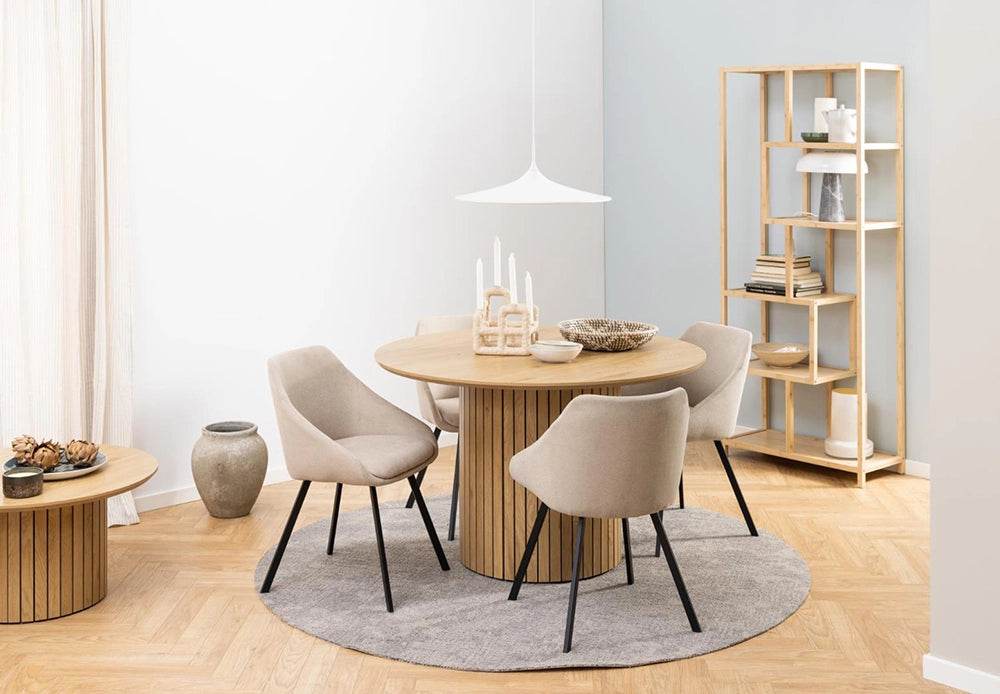 Yales Round Dining Table in Matte Oak Finish with Lounge Chair and Wooden Bookshelves in Breakout Setting