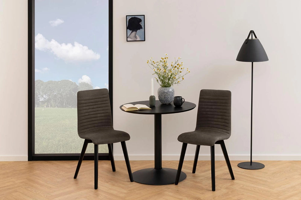 Antonio Cafe Table in Black Finish with Upholstered Grey Chair and Standing Lamp in Breakout Setting