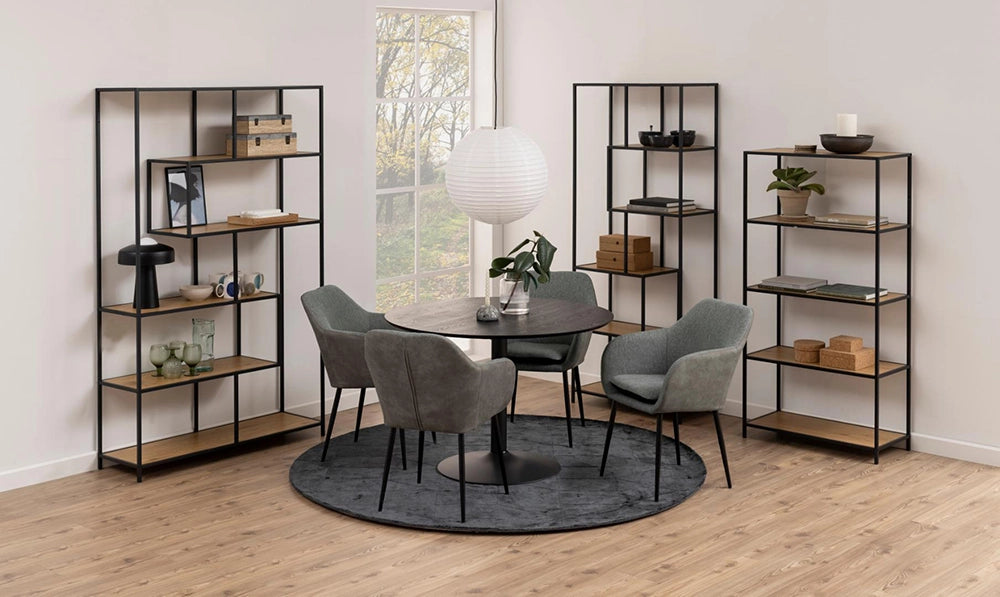 Antonio Round Dining Table in Black Finish with Grey Lounge Chair and Bookshelves in Breakout Setting