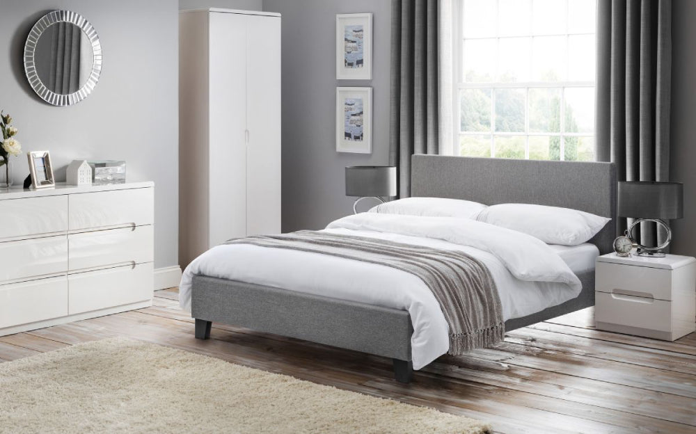 Arika Bed Frame in Light Grey Finish with Bedside Table and Lampshade in Bedroom Setting