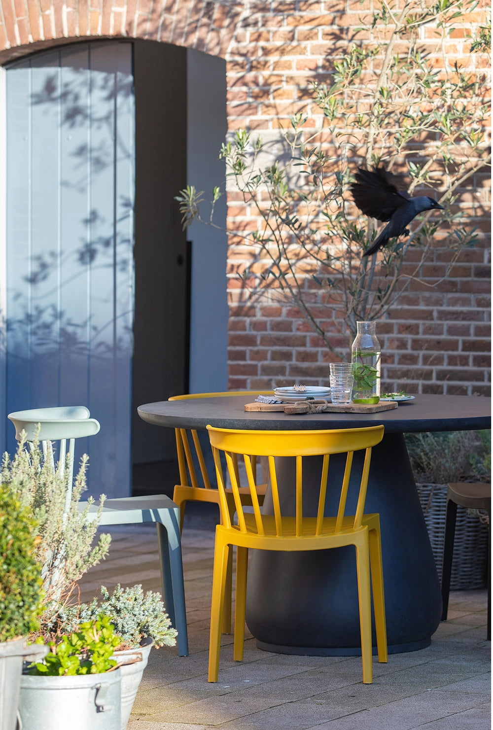 Ash Polypropylene Chair Ochre 5 with Matching Light Green Chair and Black Round Table in Outdoor Setting