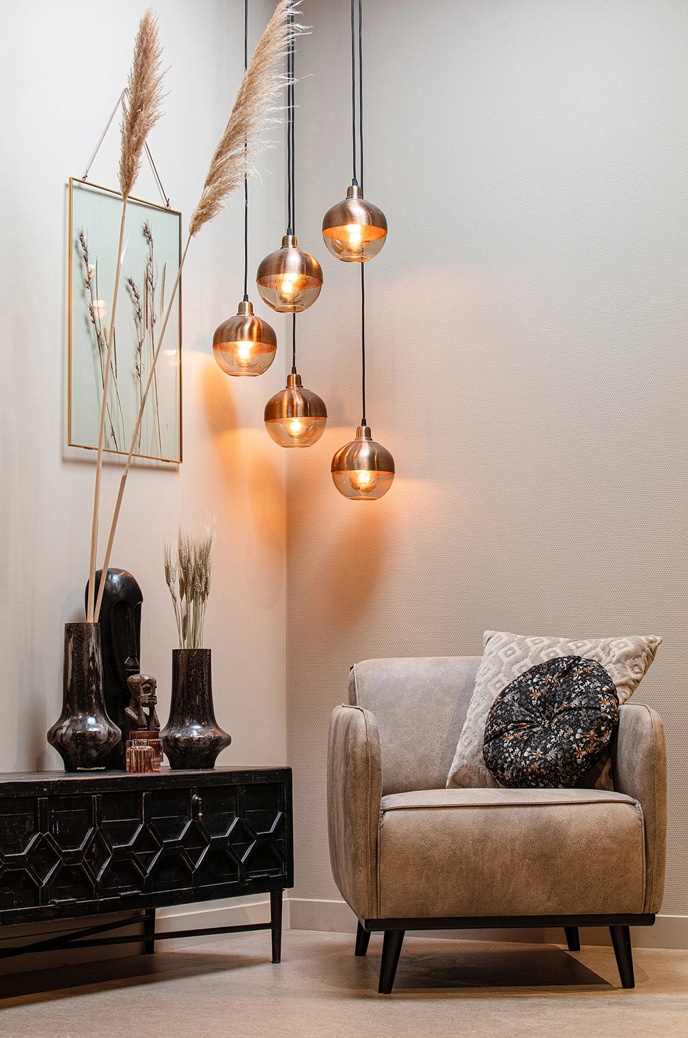 Bella TV Unit in Black Finish with Upholstered Armchair and Hanging Lights in Living Room Setting