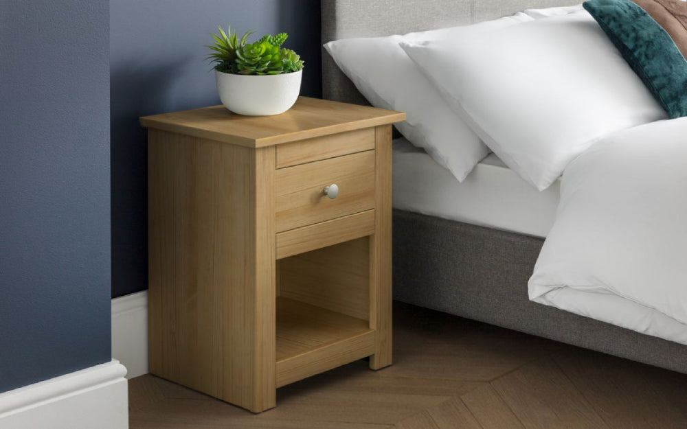 Bradley Bedside Table in Waxed Pine Finish with Indoor Plant and Pillows in Bedroom Setting
