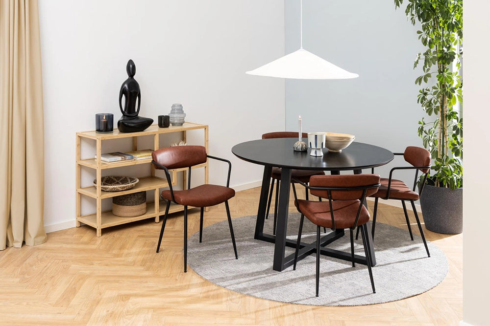 Court Round Dining Table in Black Finish with Brown Armchair and Indoor Plant in Living Room Setting