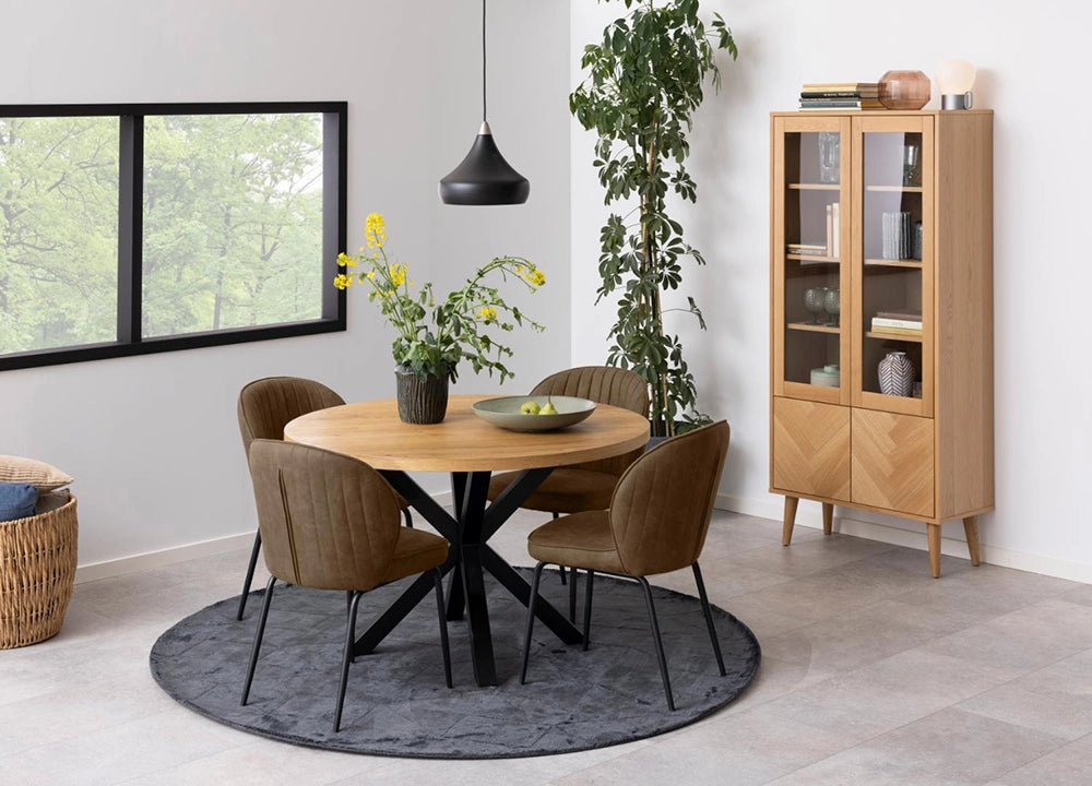 Evan Round Dining Table in Oak Black Finish with Upholstered Brown Chair and Indoor Plant in Dining Setting