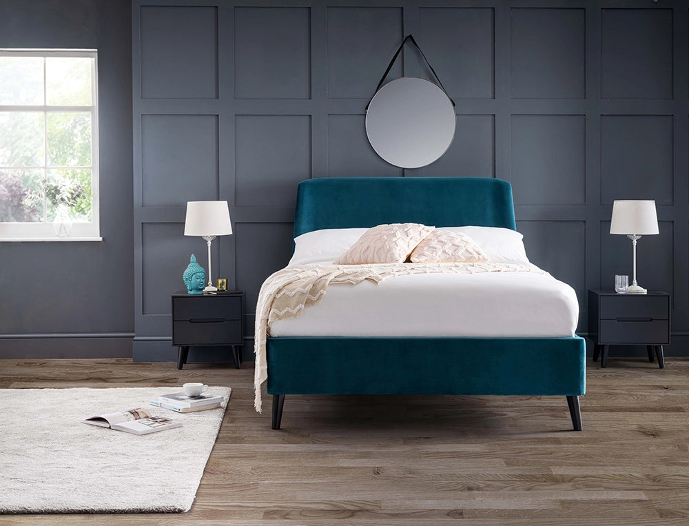 Fred Curved Velvet Bed in Teal Finish with White Lampshade and Round Mirror in Bedroom Setting