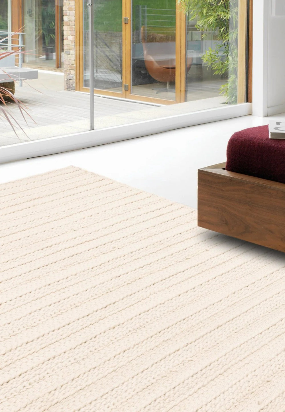 Gloria Hand Woven Floor Rug in Cream Finish with Lounge Chair in Living Room Setting