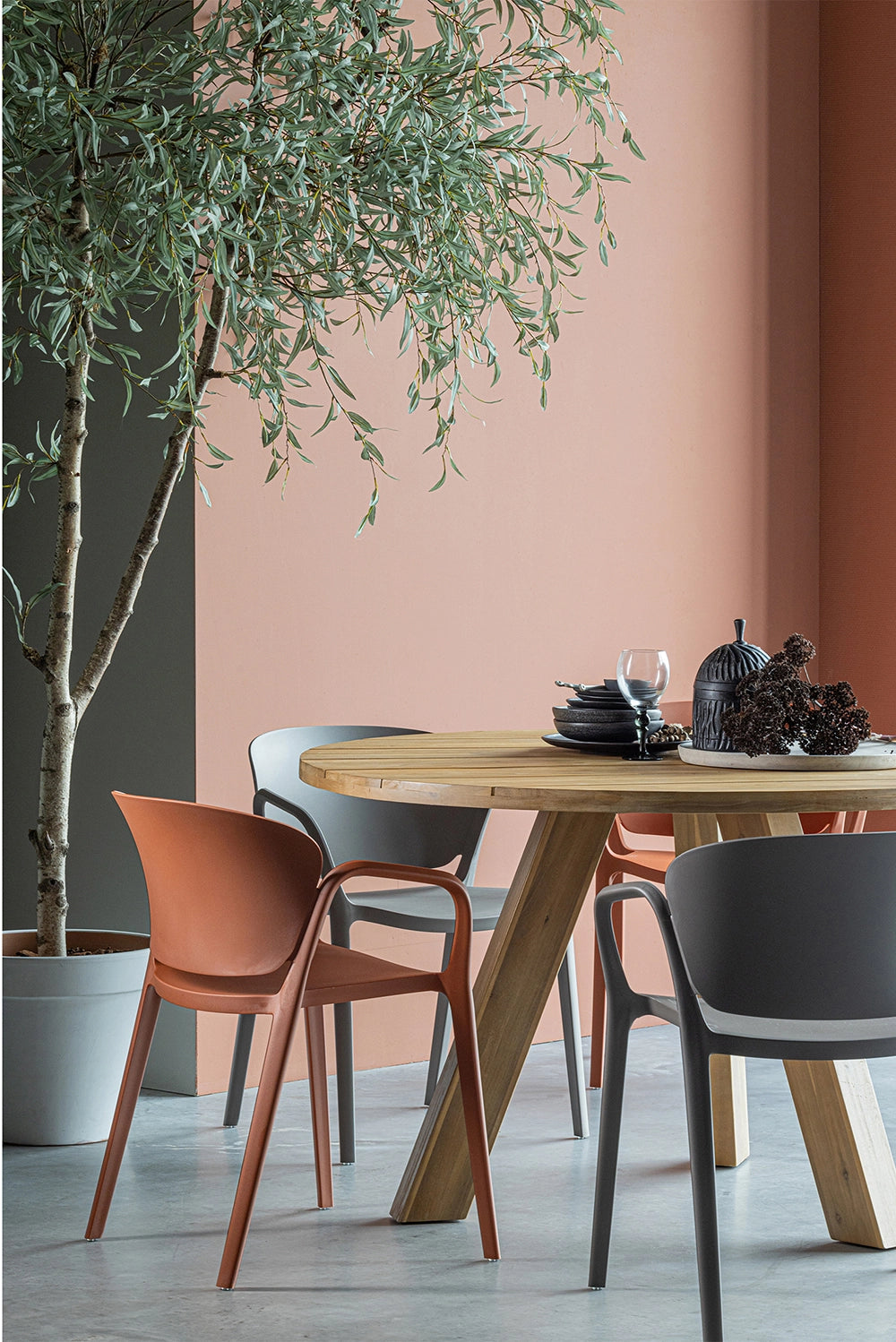 Greta Polypropylene Chair Taupe with Greta Chair in Terra and Round Wooden Table in Dining Area Setting