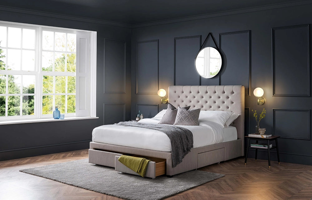 Hilton Deep Button 4 Drawer Bed in Grey Finish Linen with Wall Lamp and Round Mirror in Bedroom Setting