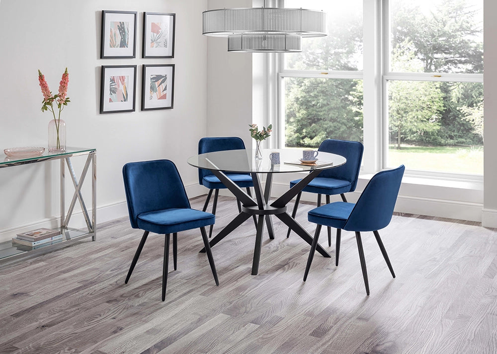 Jayden Round Dining Table in Glass Top with Padded Blue Chairs and Tansparent Vase in Breakout Setting