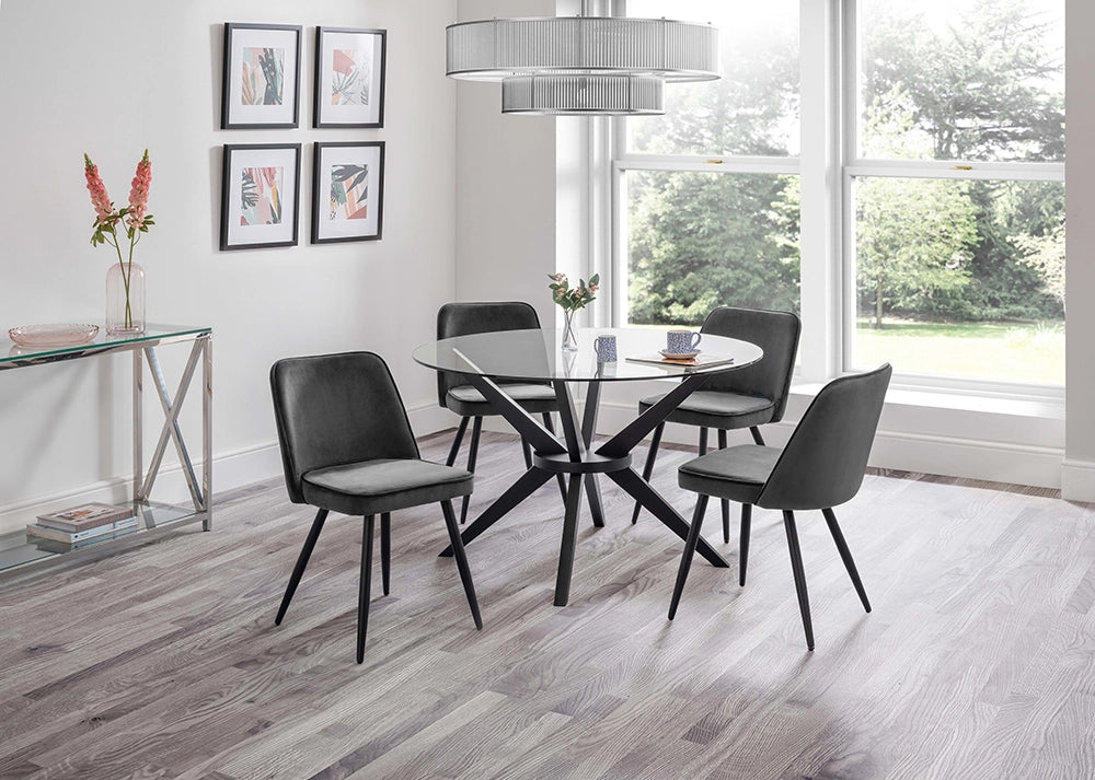 Jayden Round Dining Table in Glass Top with Padded Grey Chairs and Tansparent Vase in Breakout Setting