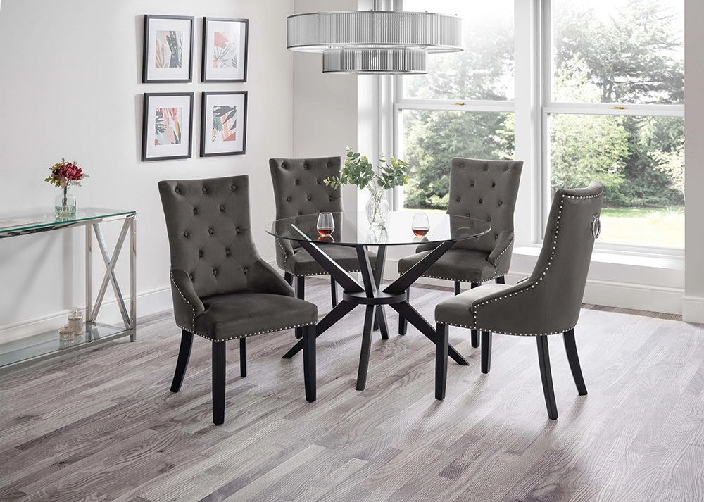 Jayden Round Dining Table in Glass Top with Padded High Back Chairs and Tansparent Vase in Breakout Setting