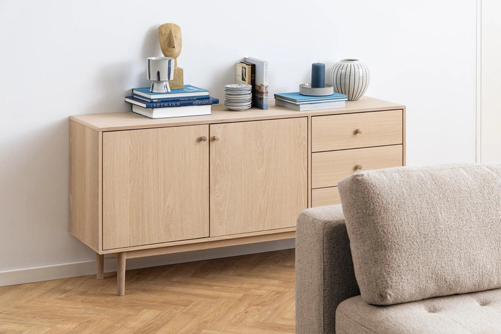 Krutcher Sideboard in White Oak Finish with Upholstered Sofa and Books in Living Room Setting