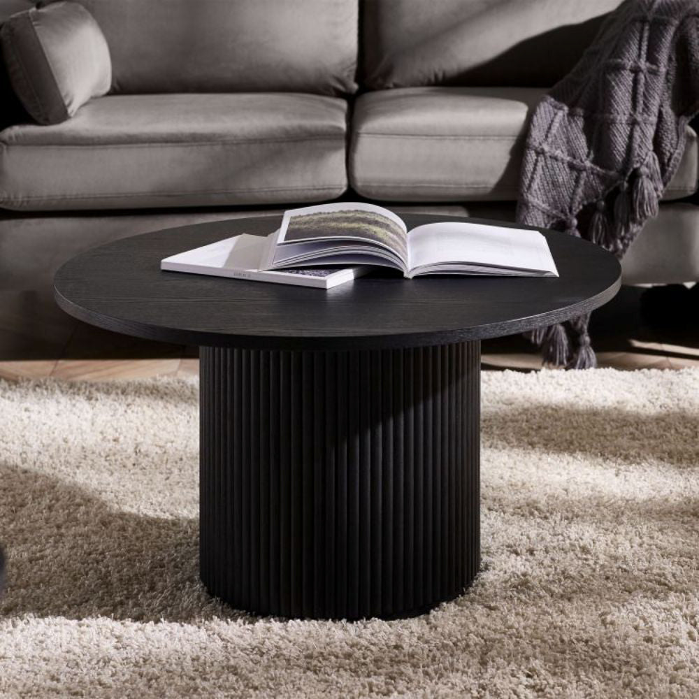 Lishan Round Coffee Table in Ash Black Finish with Floor Rug and Sofa in Living Room Setting