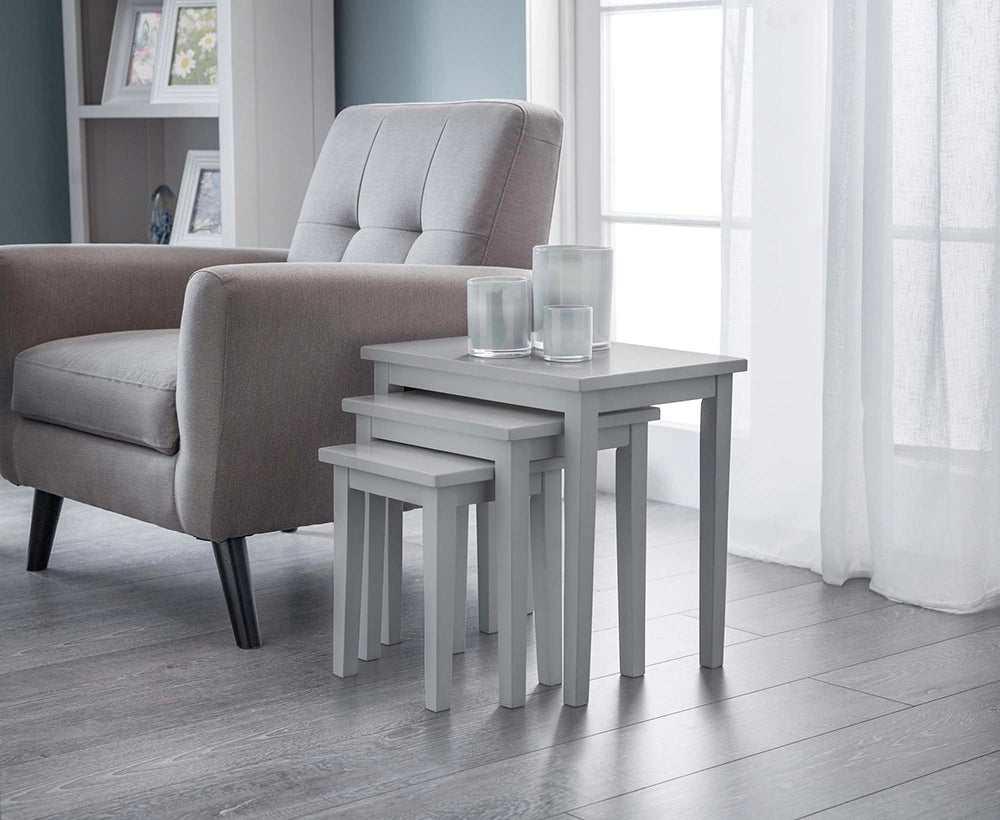 Lyon Nest Of Table in Grey Finish with Upholstered Grey Armchair and Transparent Glass Candle in Living Room Setting
