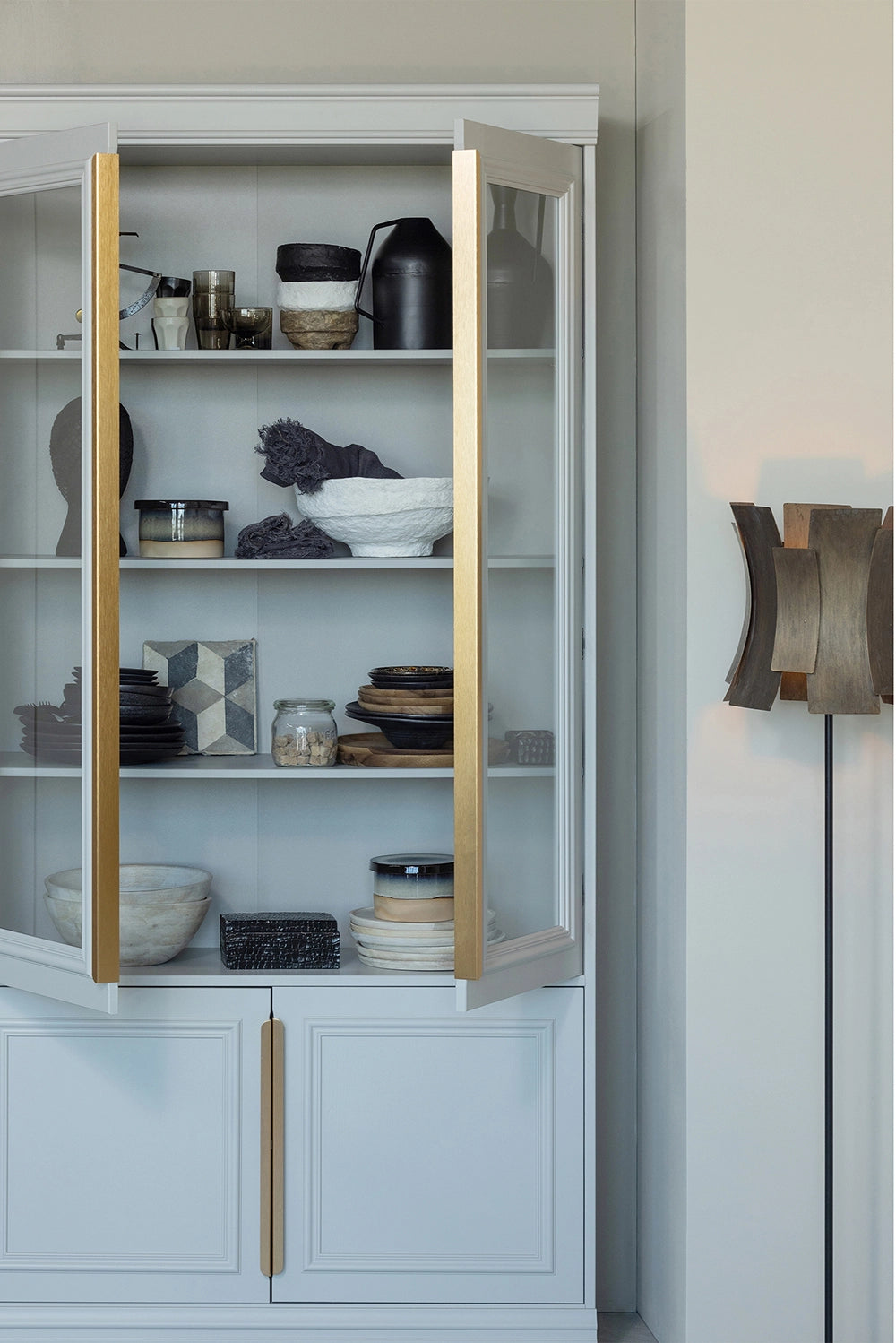Maca Display Cabinet in Mist Finish with Utensils and Standing Lamp in Living Room Setting