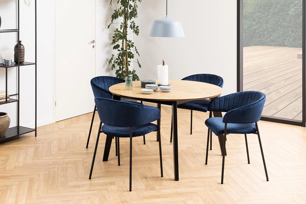Mahon Extending Dining Table in Matte Oak Finish with Blue Chair and Indoor Plant in Dining Room Setting