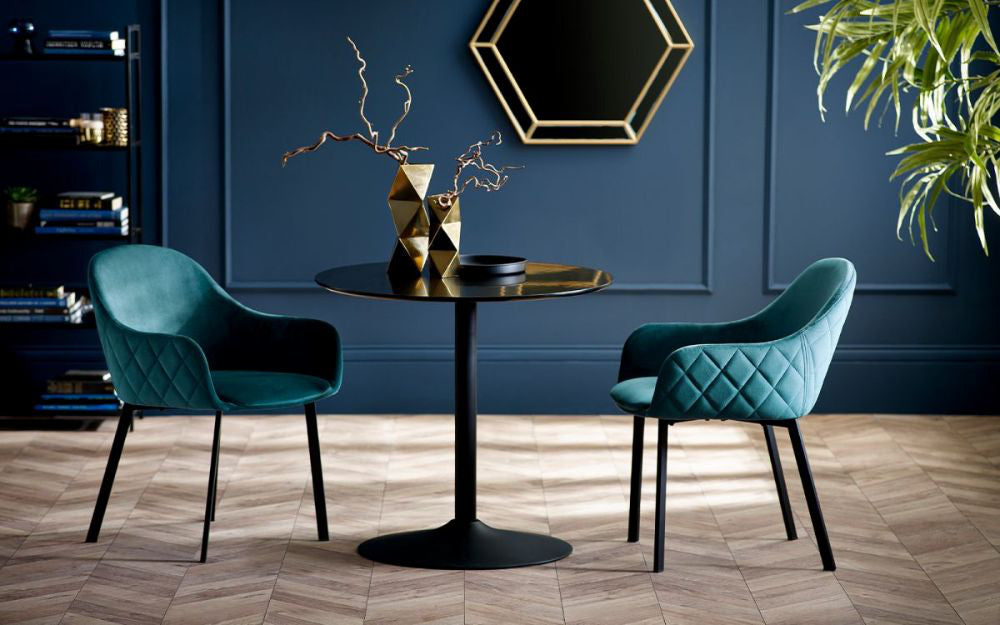 Neala Round Dining Table in Black Finish with Chairs and Indoor Plant in Reception Setting