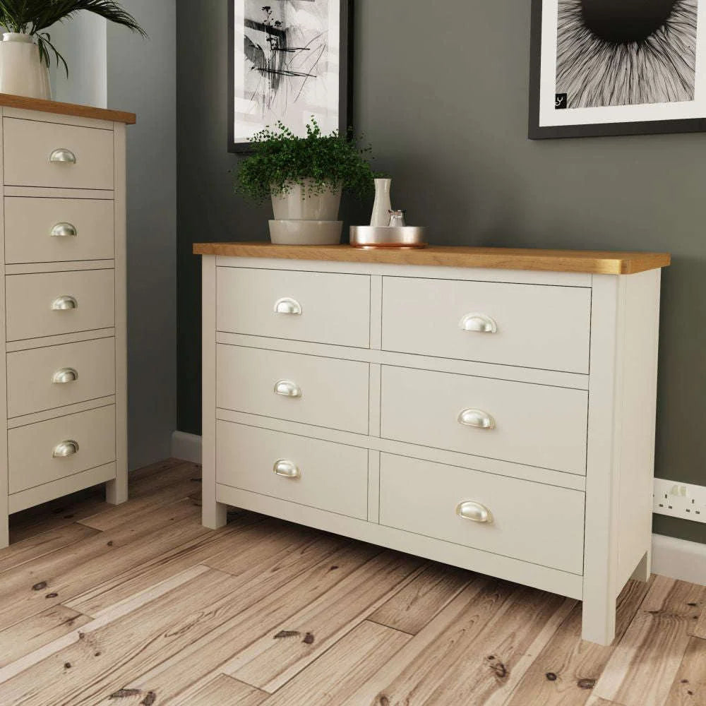 Remy 6 Drawer Chest in Truffle Finish with Indoor Plant and Wall Art in Bedroom Setting