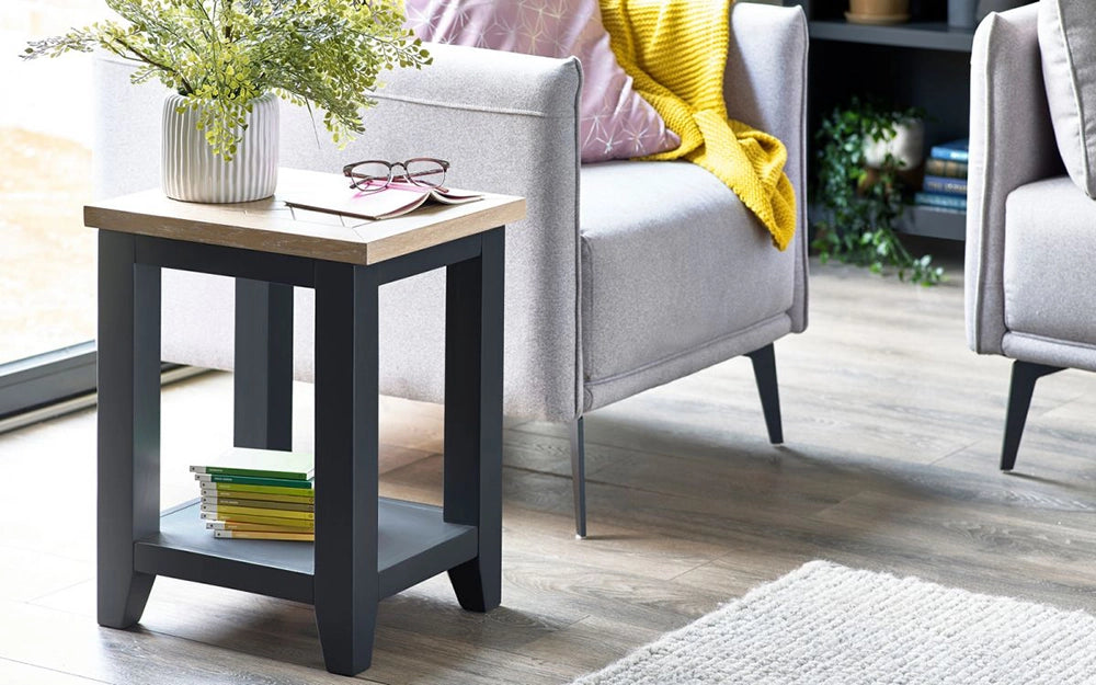 Rua Lamp Table in Dark Grey Finish with Grey Armchair and White Vase in Living Room Setting