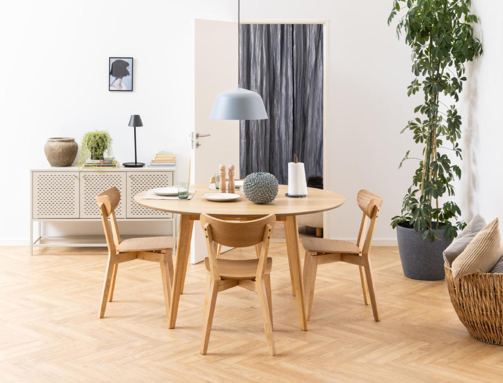 Sierra Round Dining Table in Veneered Oak Top Finish with Plant and Cupboard in Dining Setting