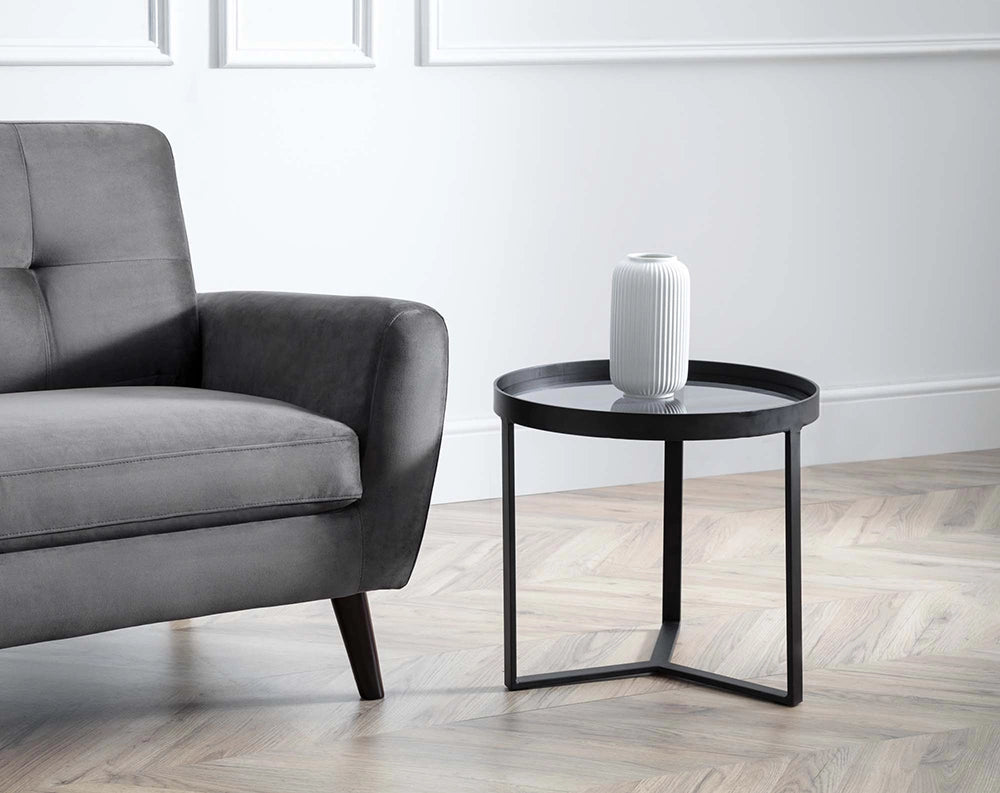 Skylar Lamp Table in Smoked Glass with White Vase and Upholstered Grey Sofa in Living Room Setting