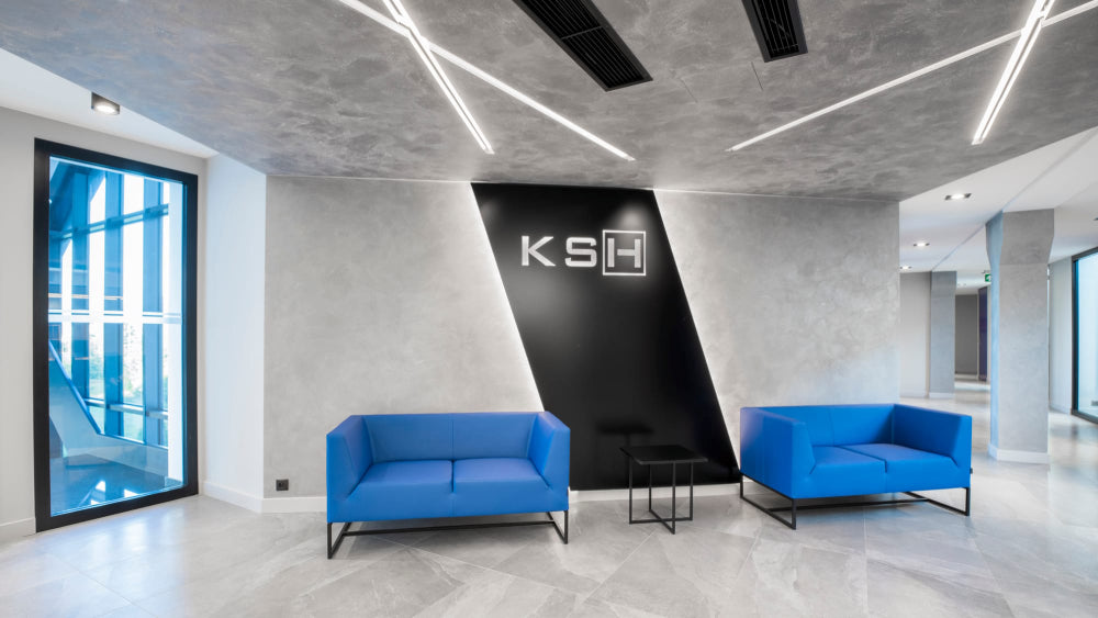 Verso-Upholstered-2-Seater-Sofa-in-Blue-Finish-with-Black-Coffee-Table-in-Reception-Setting.webp