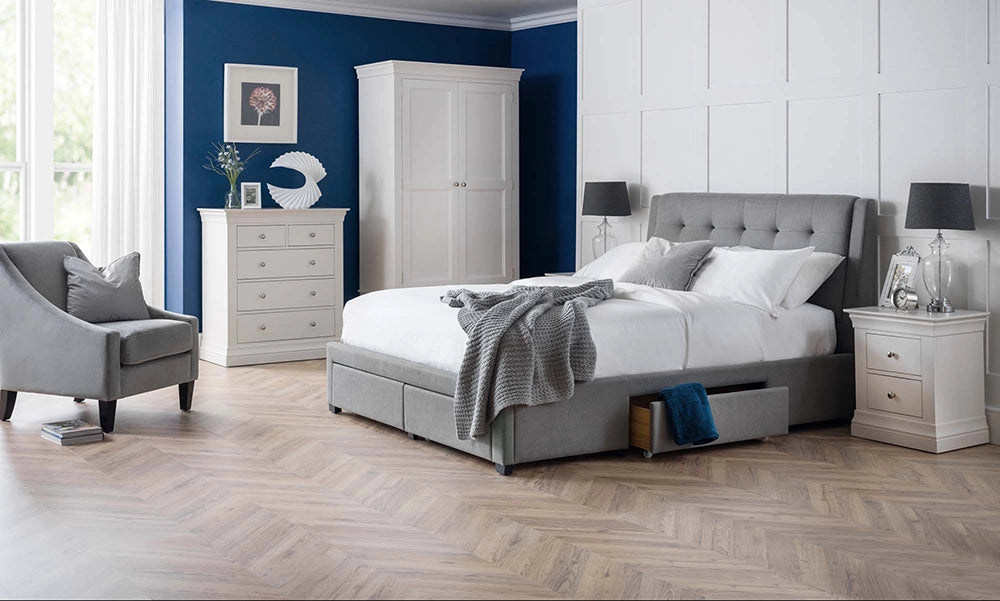 Violet 4 Drawer Bed in Grey Finish with Black Lamp Shade and Upholstered Grey Armchair in Bedroom Setting