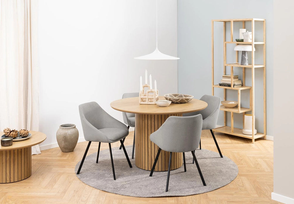 Yales Round Dining Table in Matte Oak Finish with Lounge Chair and Bookshelves in Breakout Setting